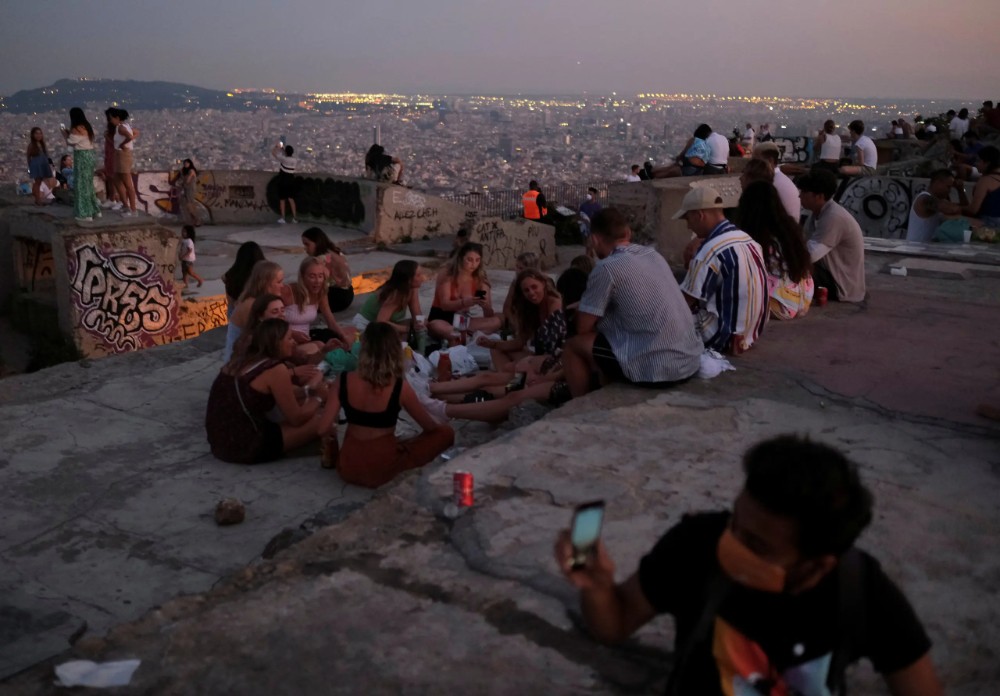 Tourists and locals gather at a lookout point, with a view of the city of Barcelona . (Reuters)