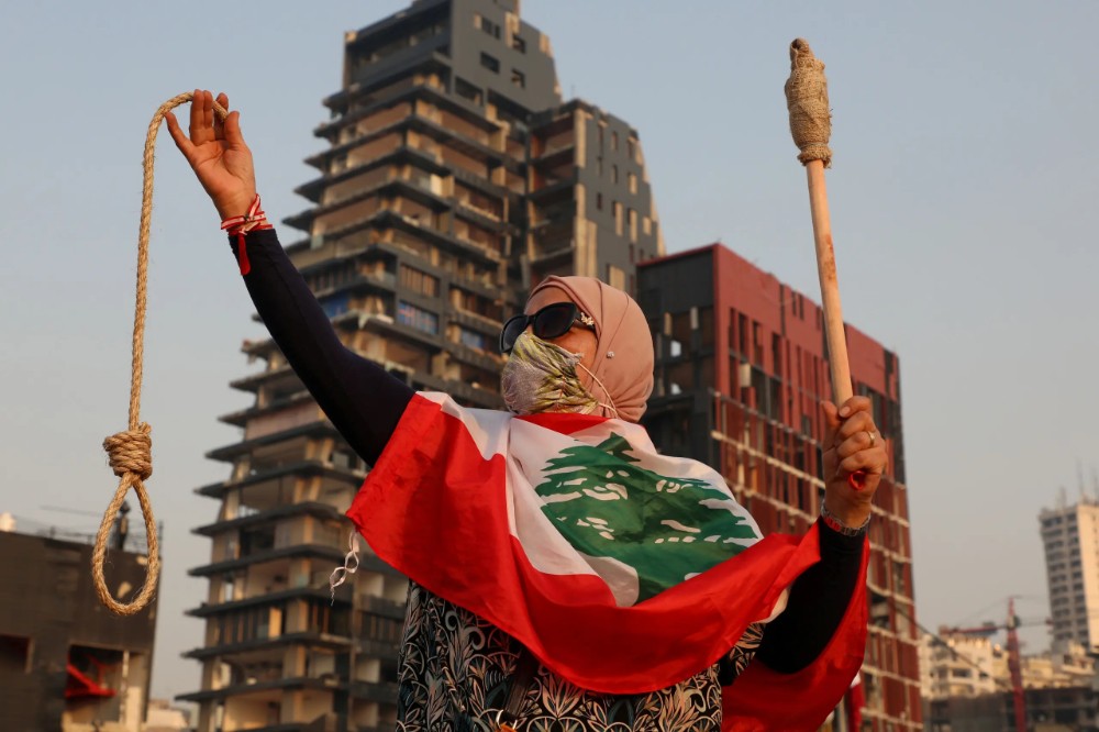 A woman holds a noose as she observes a minute of silence to mark one month since the massive explosion at the city's port area, in Beirut, Lebanon September 4, 2020. (Reuters)