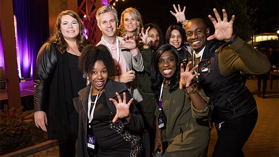 8 alumni at their class party posing with cat claw hands to show their Northwestern Pride