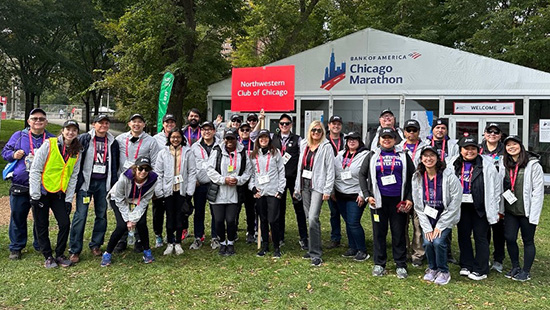Northwestern Club of Chicago members pose in front of a tent at the Chicago Marathon