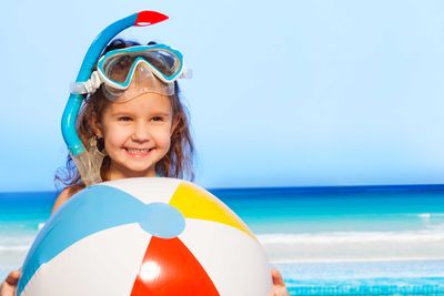 a little girl with a large beach ball
