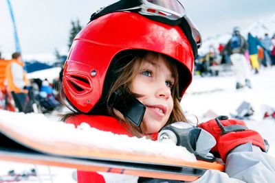 a child carrying a pair of skis