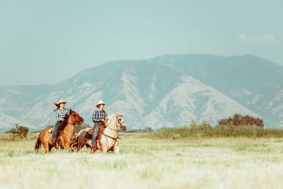 Two Cowboys Riding a Horse