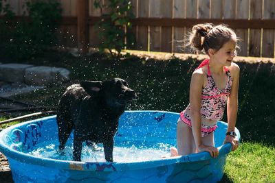 girl dog paddling pool