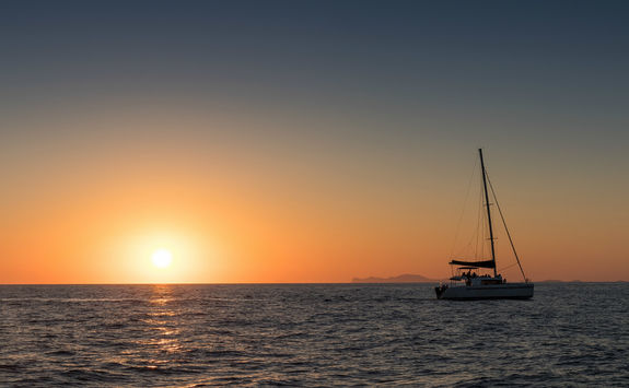 Catamaran out at sea at sunset