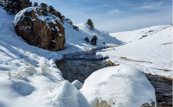 snow covered rock and river