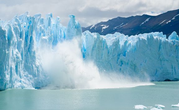 breaking ice falling from glacier