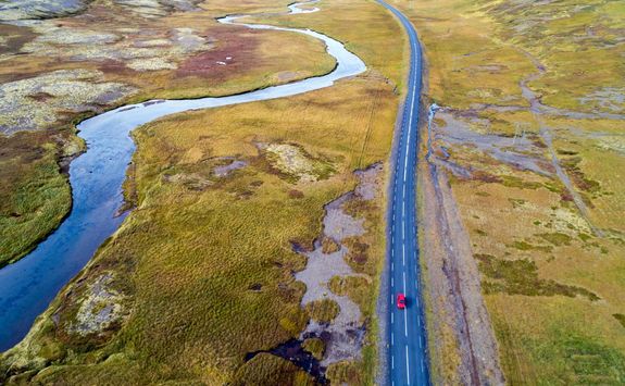 Aerial view of a red car driving on road