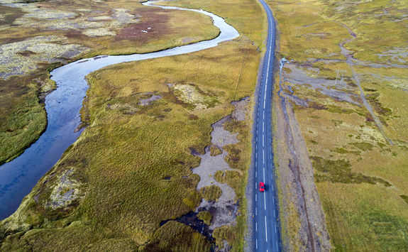 Aerial view of a red car driving on road
