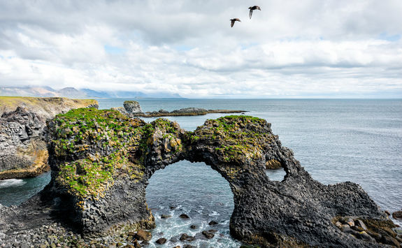 Gatklettur arch rock with two birds fly