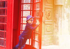 Boy running out of a London telephone box