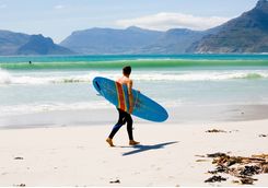Man with surfboard on Kommetjie beach