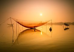 Fishermen with nets at sunset