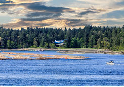 Float plane flying over a fishing boat