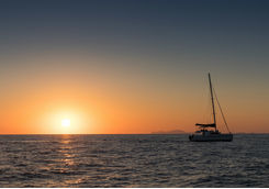 Catamaran out at sea at sunset