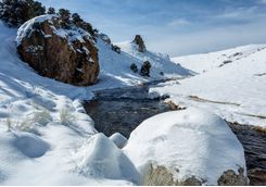 snow covered rock and river