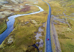 Aerial view of a red car driving on road