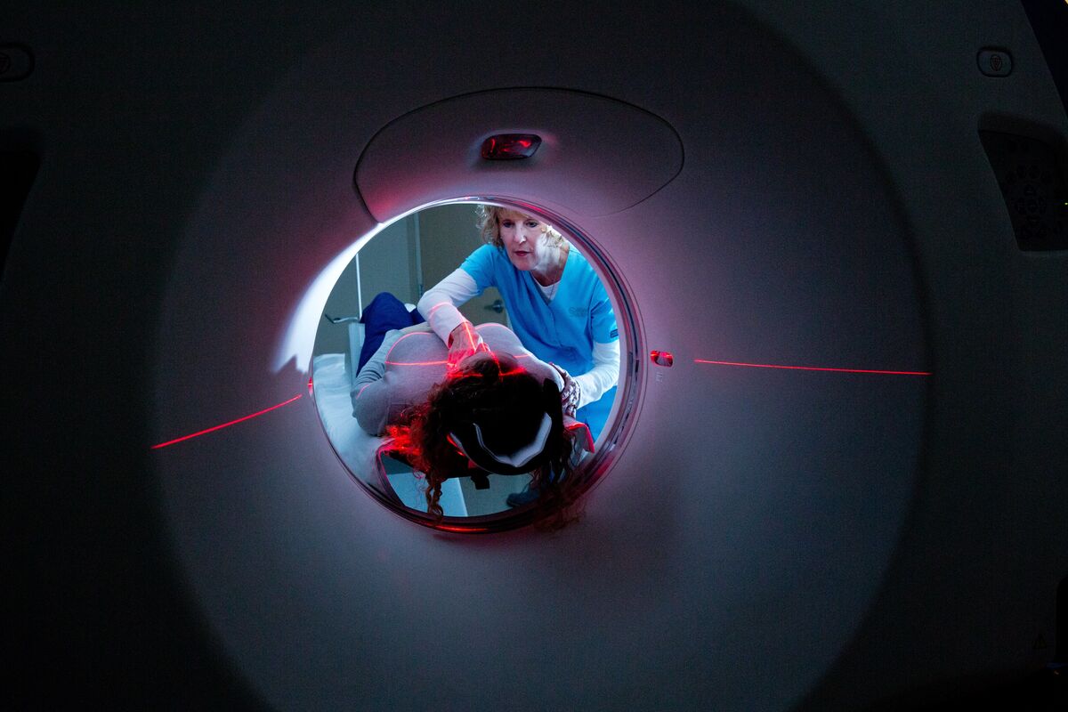 patient laying on a ct machine in a dark room