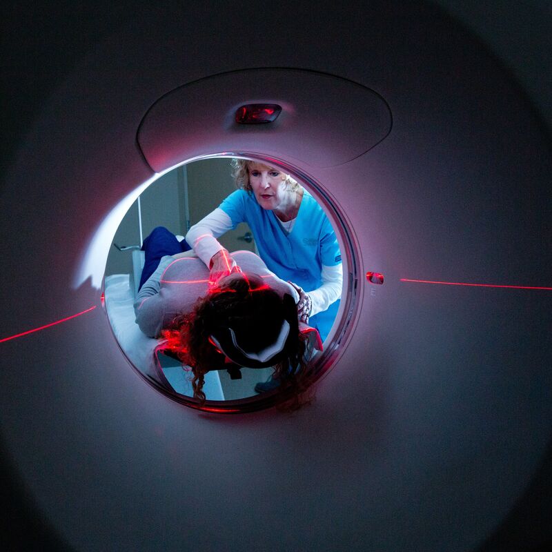 patient laying on a ct machine in a dark room