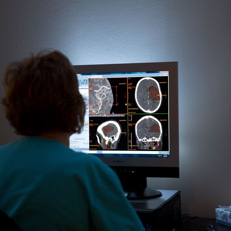 Nurse looking at mri images in a dark room