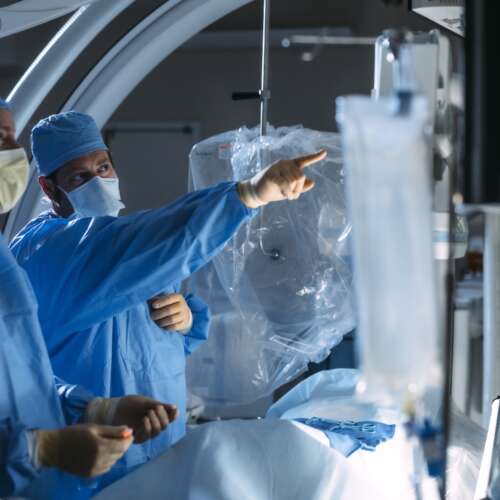 Two Doctors in A Surgery Room with One Doctor Pointing to The Image Guided Screens | Semmes Murphey