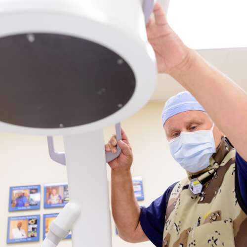 A male doctor adjusting an imaging machine during a procedure