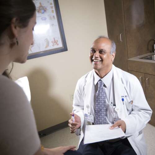 Dr. Vishad Kumar Smiling Up At a Patient - Semmes Murphey Clinic