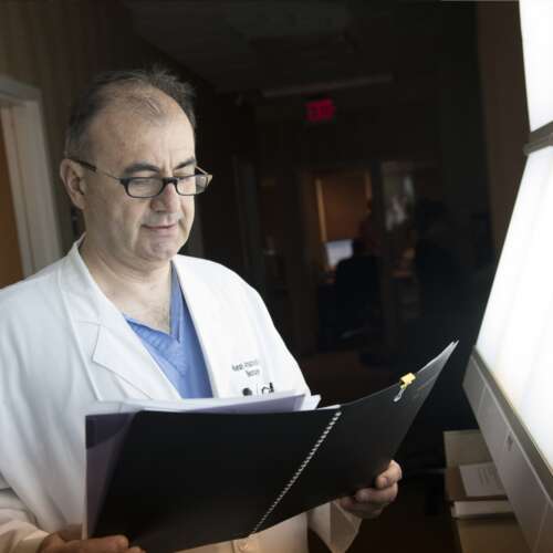 Dr. Arnautovic Looking Through a Folder at Semmes Murphey Clinic