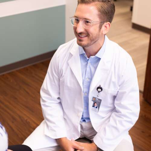 Dr. Kyle Smith, smiling while discussing with a patient
