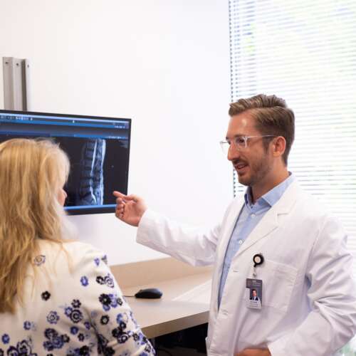 Dr. Smith explaining a spine scan to a female patient