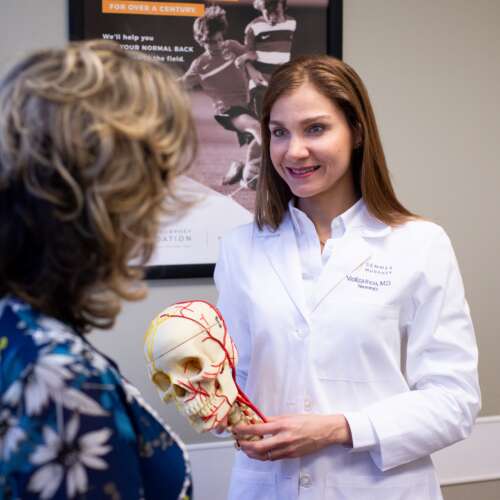 Neurology Neurologist with skull model explains to patient