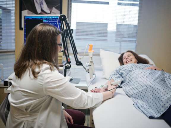 Nurse giving an EEG/NCS test to a smiling patient