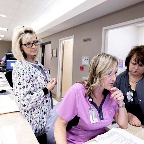 Three Nurses in the Surgery Center at Semmes Murphey looking at files