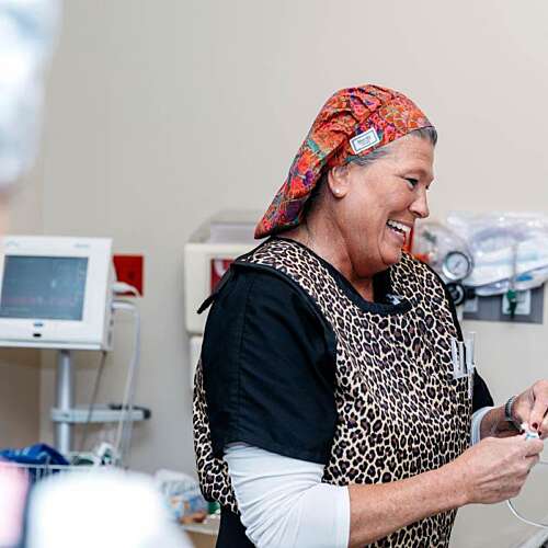 A nurse smiling down at a patient in a hospital setting