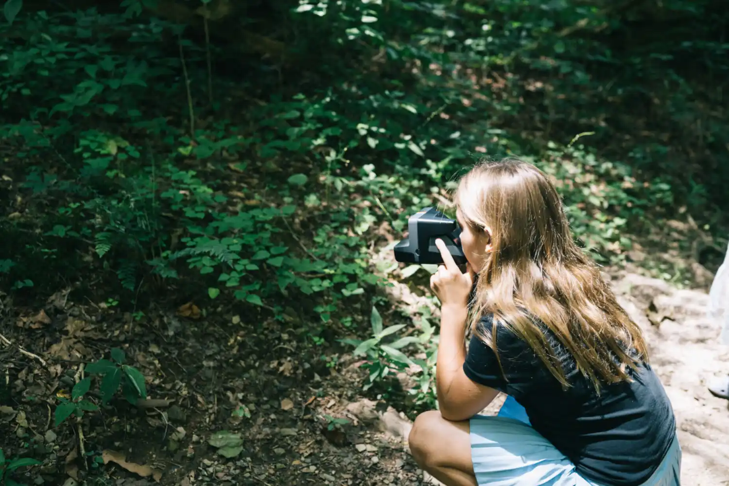 Girl Taking a Polaroid Picture for Scavenger Hunt