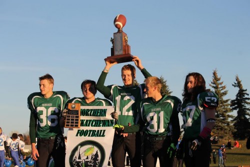 #12 Tyler Williamson of the Creighton Kodiaks hoists The Ralph Pilz Trophy as 2A champions while his team looks on.