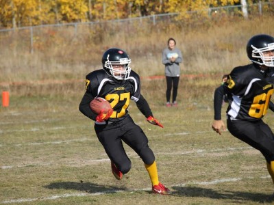 Pinehouse Laker #27 Dray Tinker following the block of teammate #60 Malachi Misponas. Dray scored four touchdowns on the day to finish with 12 on the season,
