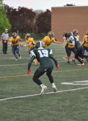 Loic Sogon (#19) defensive back of Etobicoke Eagles looks at opposing running back during a game