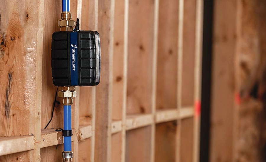 Water monitoring device attached to blue piping against wooden framing. Water monitoring device attached to blue piping against wooden framing.