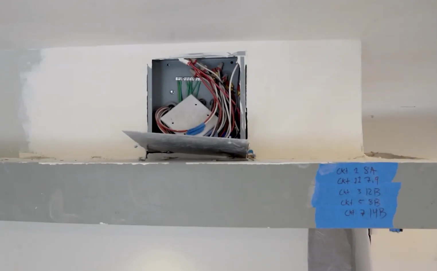 This image showcases a modern residential electrical panel installation. The electrical panel is mounted inside a wooden framework, featuring neatly organized wiring and multiple circuit breakers. Blue, orange, and white wires are systematically connected to ensure safety and functionality. The clean and professional setup reflects adherence to electrical codes and standards, indicating a high-quality electrical job suitable for residential use. This image showcases a modern residential electrical panel installation. The electrical panel is mounted inside a wooden framework, featuring neatly organized wiring and multiple circuit breakers. Blue, orange, and white wires are systematically connected to ensure safety and functionality. The clean and professional setup reflects adherence to electrical codes and standards, indicating a high-quality electrical job suitable for residential use.