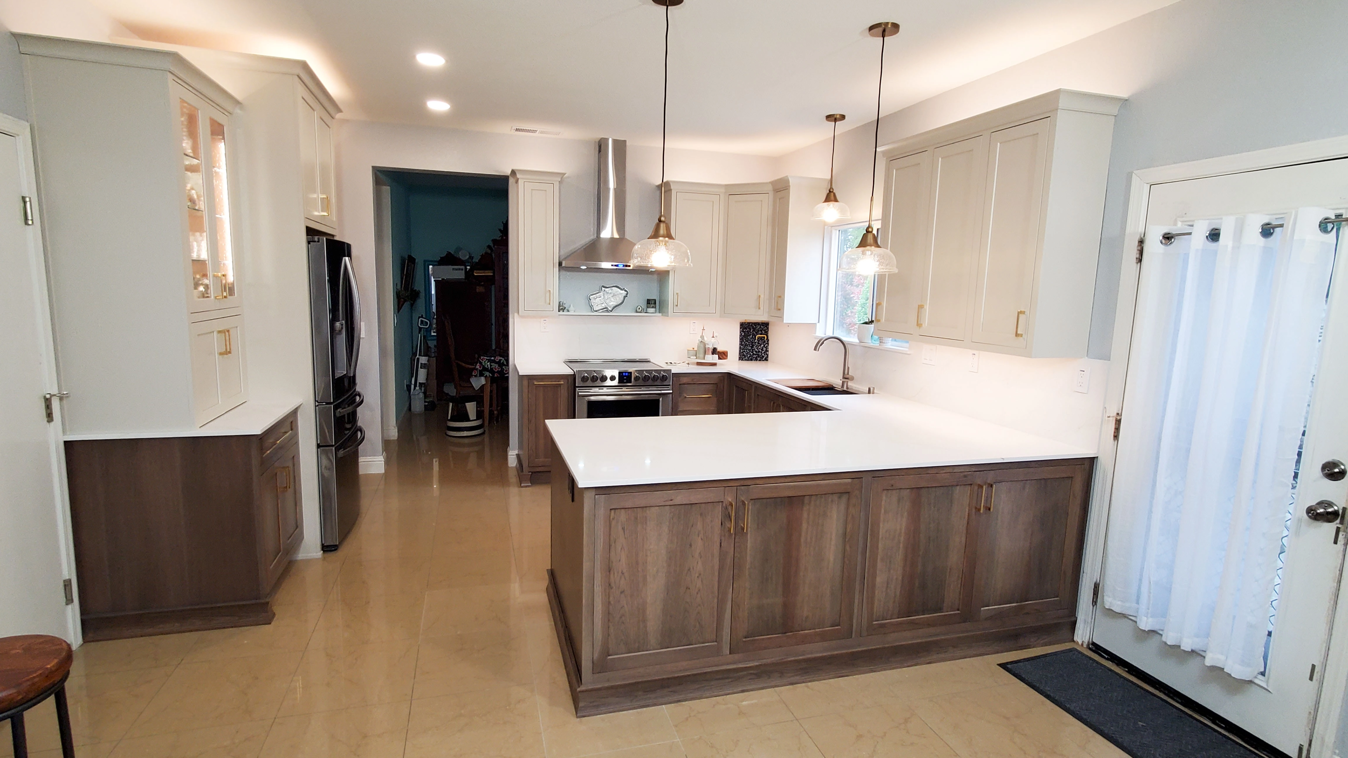  Modern kitchen with an island, pendant lights, wooden cabinets, and stainless steel appliances.