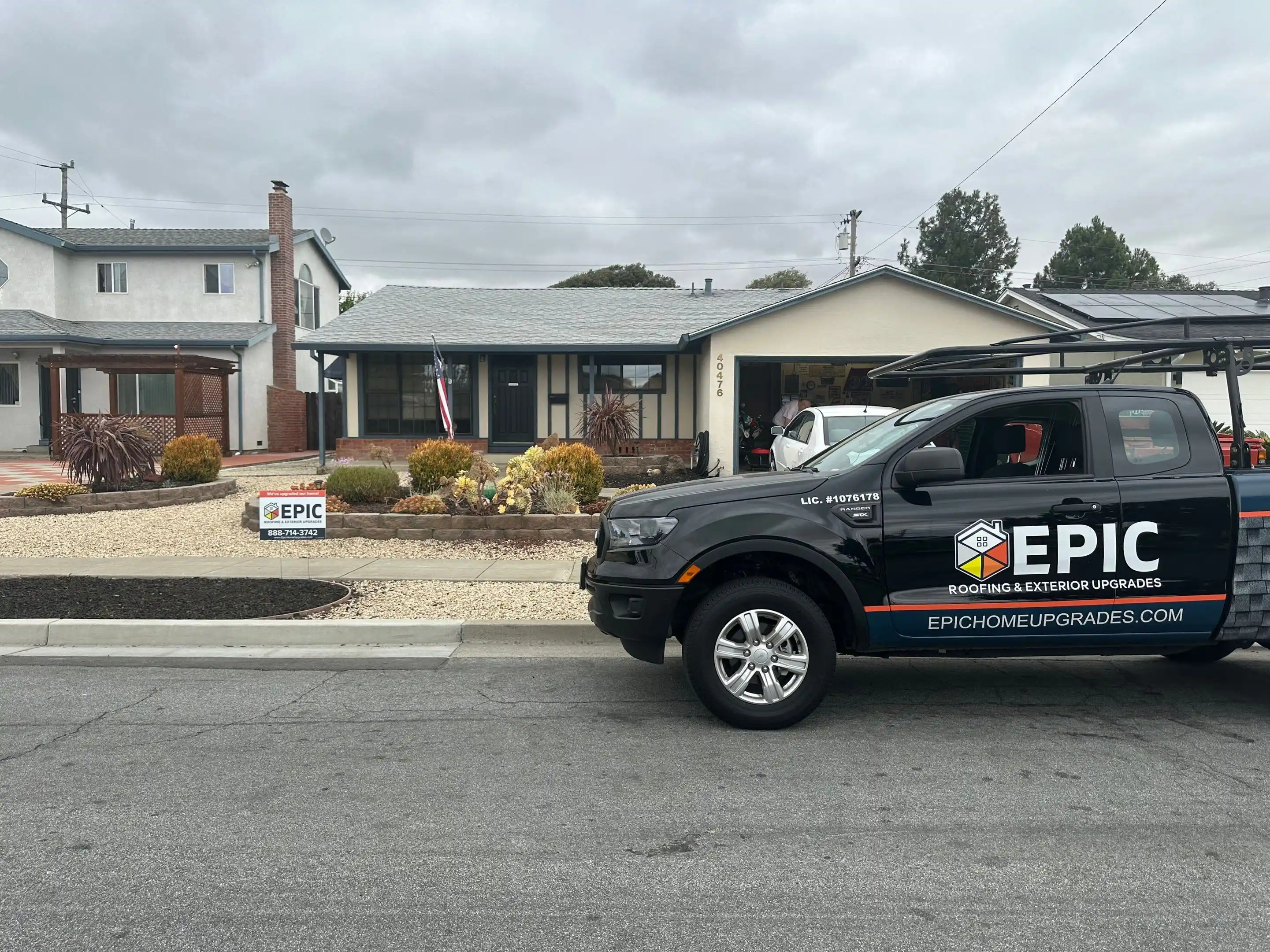A suburban house with a newly completed roof, an Epic sign in the yard, and an Epic-branded truck parked on the street. A suburban house with a newly completed roof, an Epic sign in the yard, and an Epic-branded truck parked on the street.