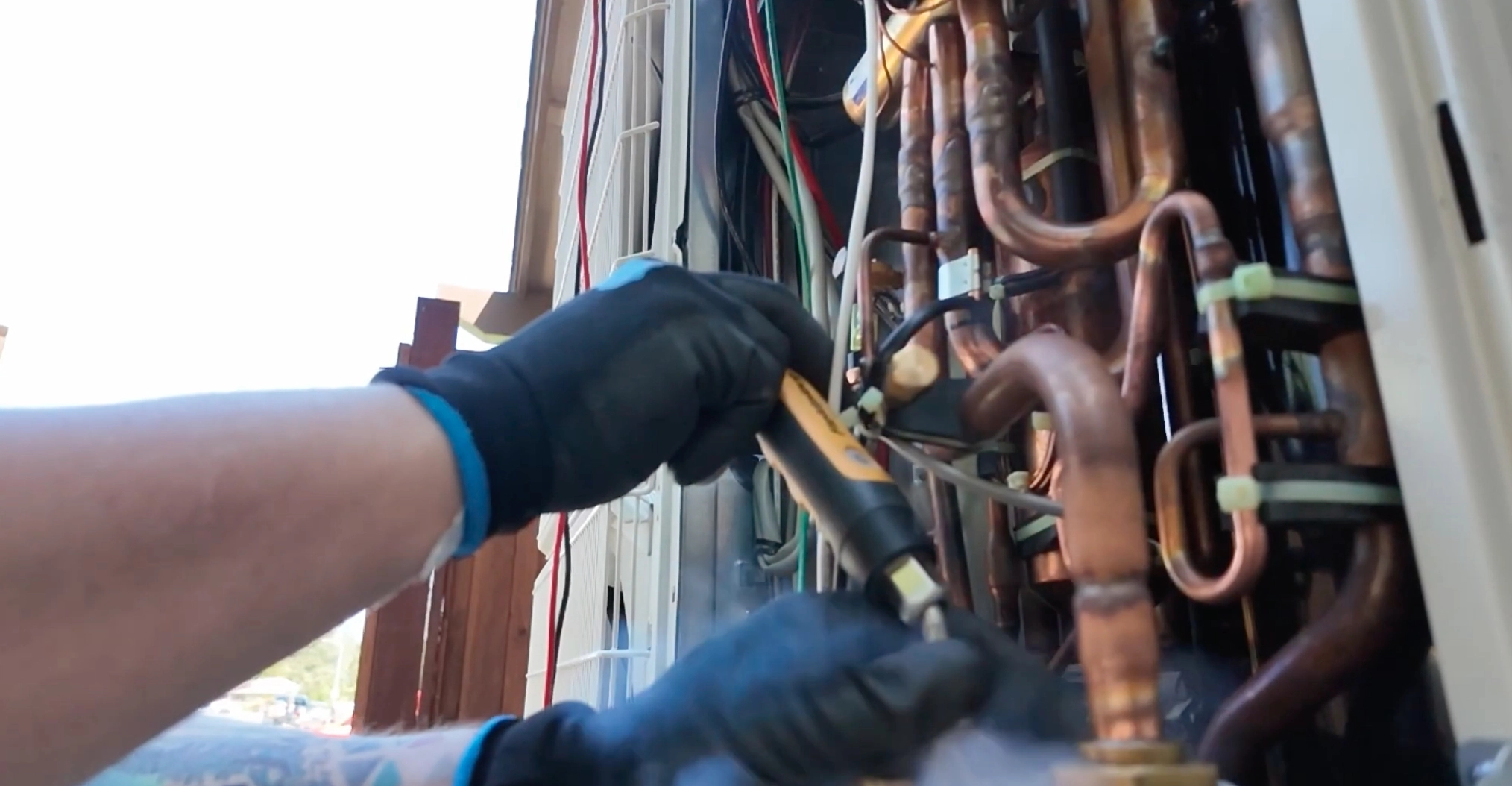 In this image, two skilled HVAC technicians from Galaxy Heating and Air Conditioning are performing maintenance on an outdoor air conditioning unit. Both technicians are wearing navy blue uniforms branded with the company logo, and one is holding a set of gauges connected to the HVAC system to check pressure levels and ensure optimal performance. The unit is situated outdoors next to a residential building, indicating a typical home HVAC service scenario. Their focused and professional approach highlights the company’s commitment to quality and reliable heating and cooling solutions. In this image, two skilled HVAC technicians from Galaxy Heating and Air Conditioning are performing maintenance on an outdoor air conditioning unit. Both technicians are wearing navy blue uniforms branded with the company logo, and one is holding a set of gauges connected to the HVAC system to check pressure levels and ensure optimal performance. The unit is situated outdoors next to a residential building, indicating a typical home HVAC service scenario. Their focused and professional approach highlights the company’s commitment to quality and reliable heating and cooling solutions.