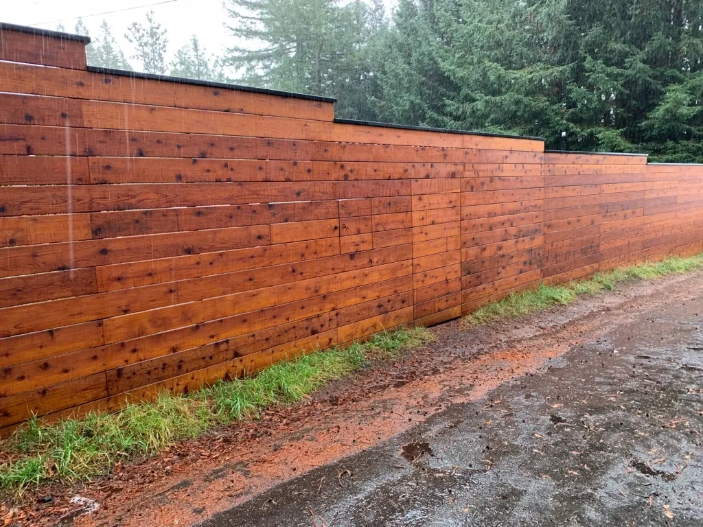 This image showcases a sturdy and sleek metal fence installed alongside a residential property. The fence features vertical black metal bars with decorative spearhead tops, providing both security and aesthetic appeal. The design blends durability with modern sophistication, making it suitable for enhancing the curb appeal and safety of the home. The fence is complemented by a concrete base and neatly maintained surroundings, reflecting quality craftsmanship and attention to detail. This image showcases a sturdy and sleek metal fence installed alongside a residential property. The fence features vertical black metal bars with decorative spearhead tops, providing both security and aesthetic appeal. The design blends durability with modern sophistication, making it suitable for enhancing the curb appeal and safety of the home. The fence is complemented by a concrete base and neatly maintained surroundings, reflecting quality craftsmanship and attention to detail.