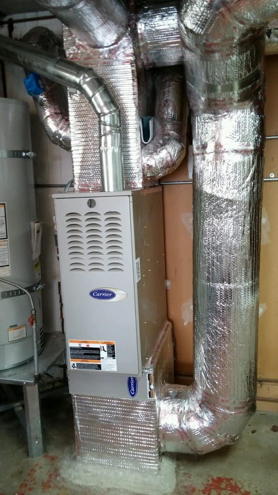 Carrier furnace and water heater surrounded by reflective insulated HVAC ductwork in a utility room. Carrier furnace and water heater surrounded by reflective insulated HVAC ductwork in a utility room.