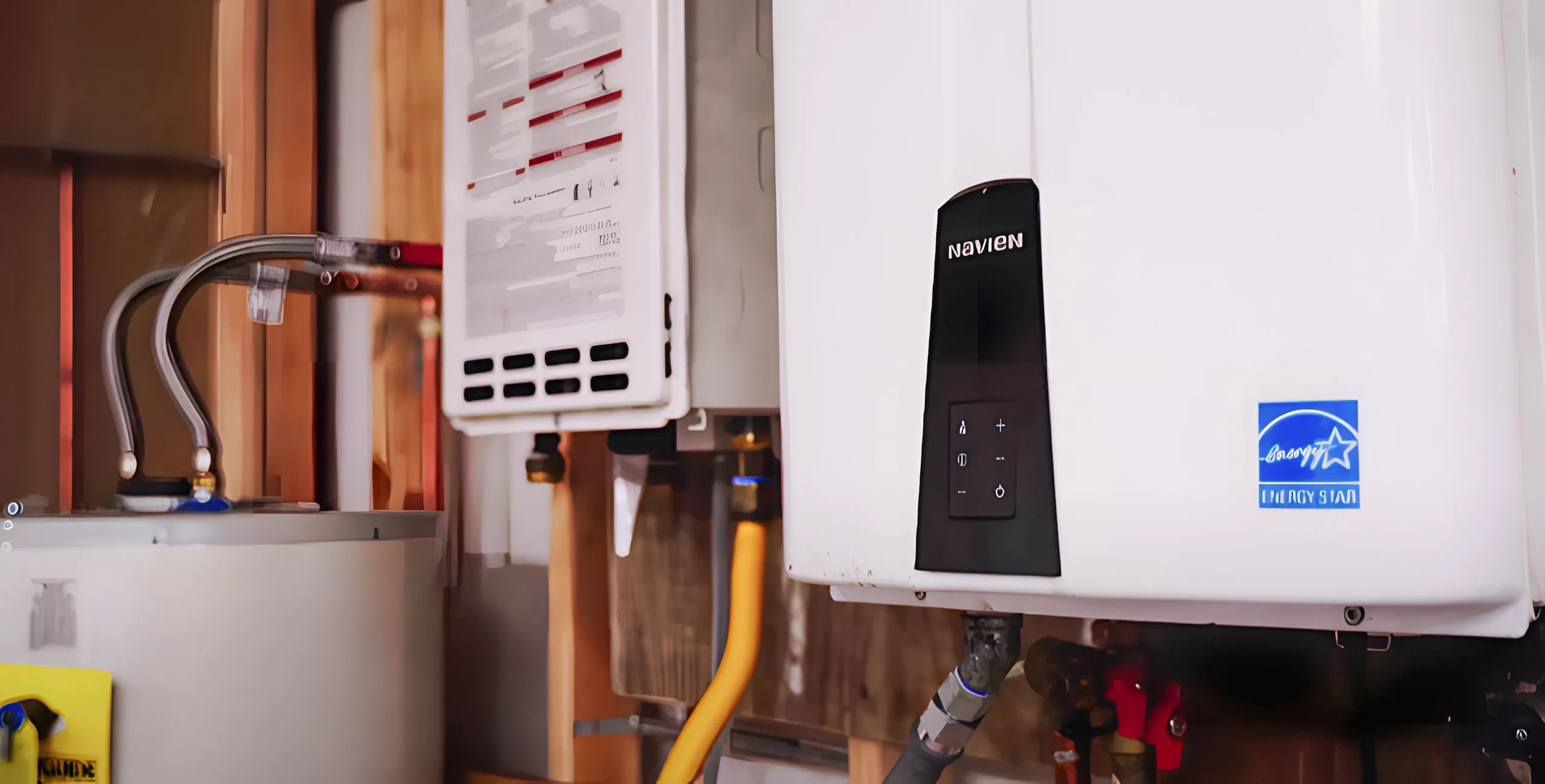 Close-up of a tankless water heater with visible pipes and Energy Star label. Close-up of a tankless water heater with visible pipes and Energy Star label.