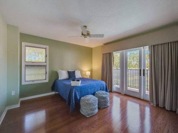 Queen bedroom on 2nd floor with access to shared hallway bathroom and balcony.