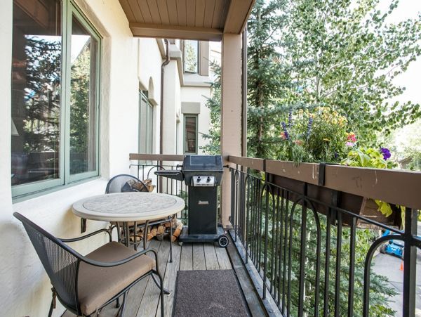 Deck with outdoor table seating for 2 and gas grill.