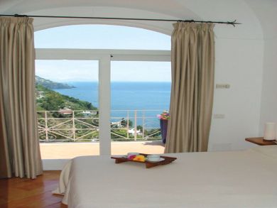 Queen bedroom with glass double doors opening to terrace