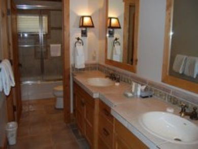 Bathroom with dual vanity & shower in tub